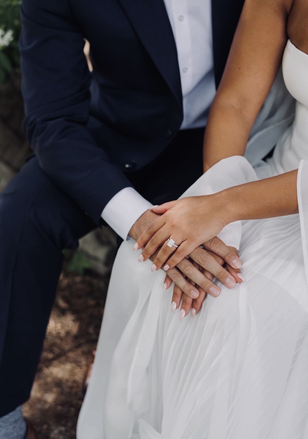 Chloe and Sam's hands resting together with her engagement ring
