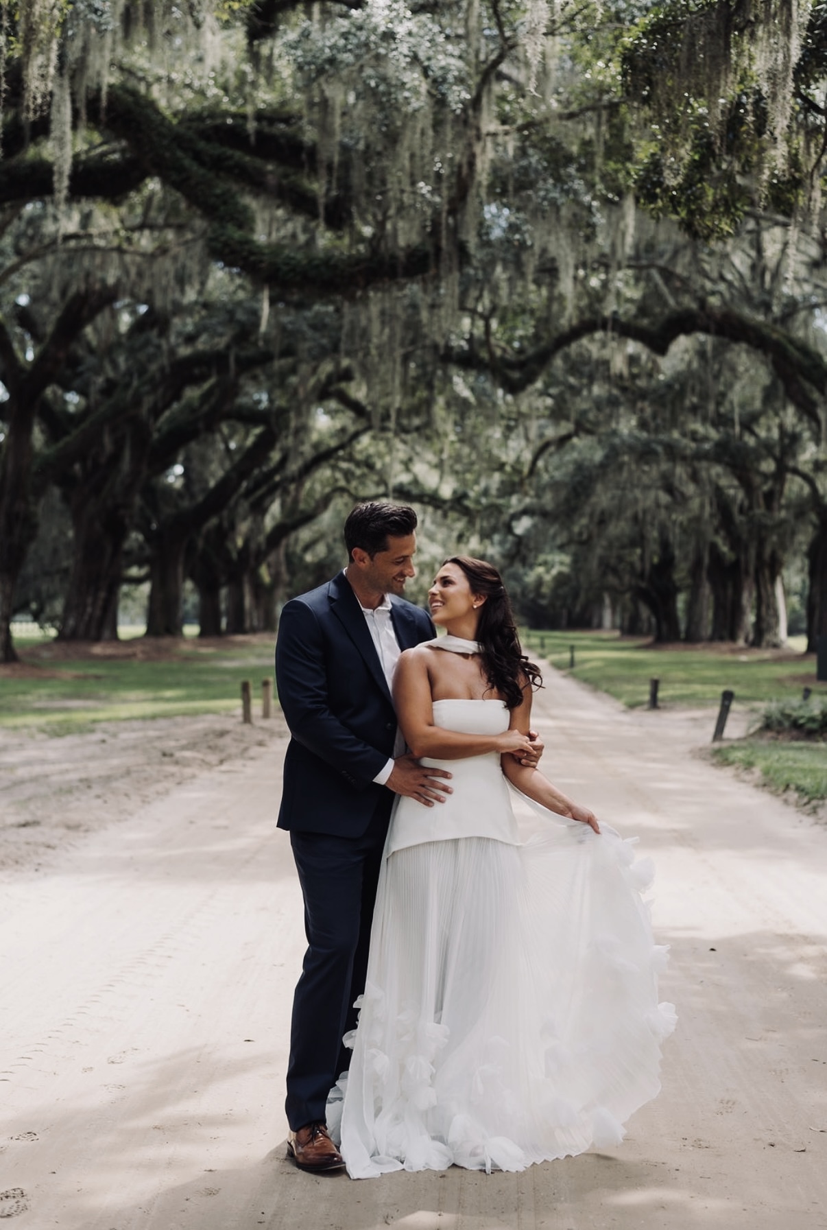 Chloe and Sam holding each other on the avenue of oaks